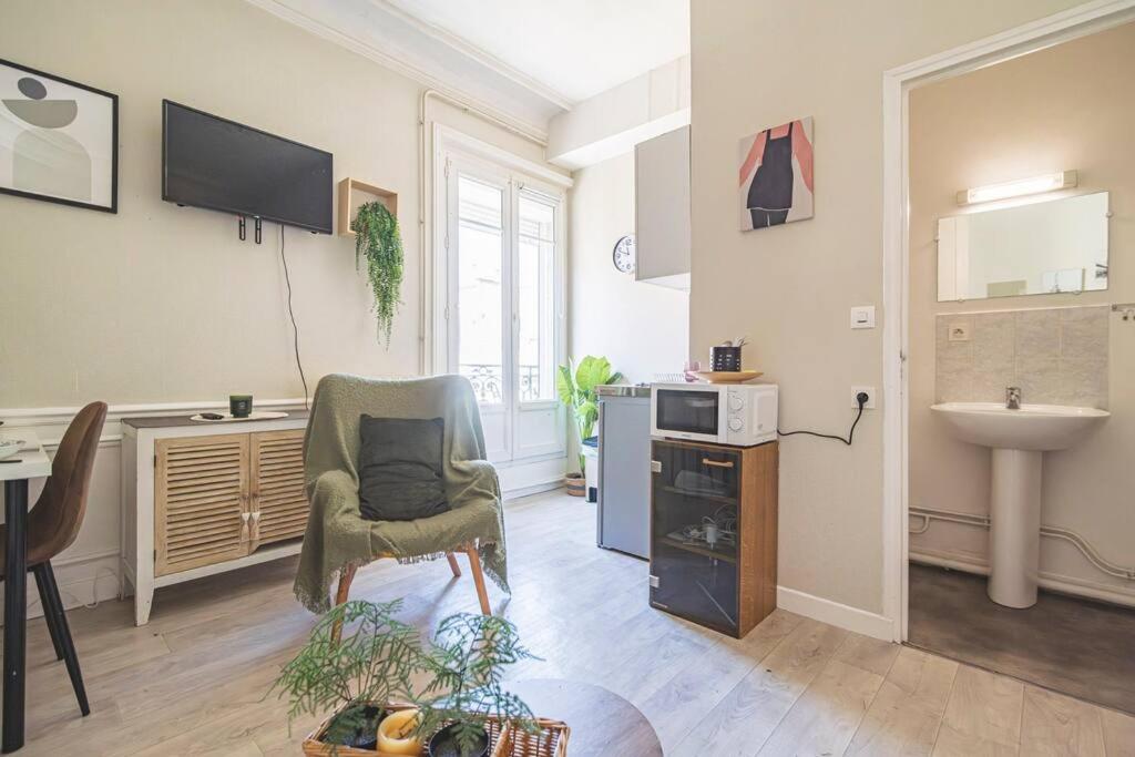 - un salon avec une chaise et un lavabo dans l'établissement Saint Rémi 522, à Reims