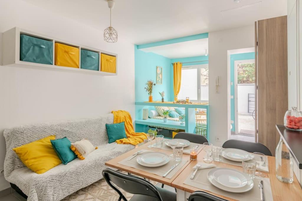 un salon avec une table et un canapé dans l'établissement Logement prive et calme EUREXPO Groupama Stadium TRAM Parking Terasse, à Saint-Priest