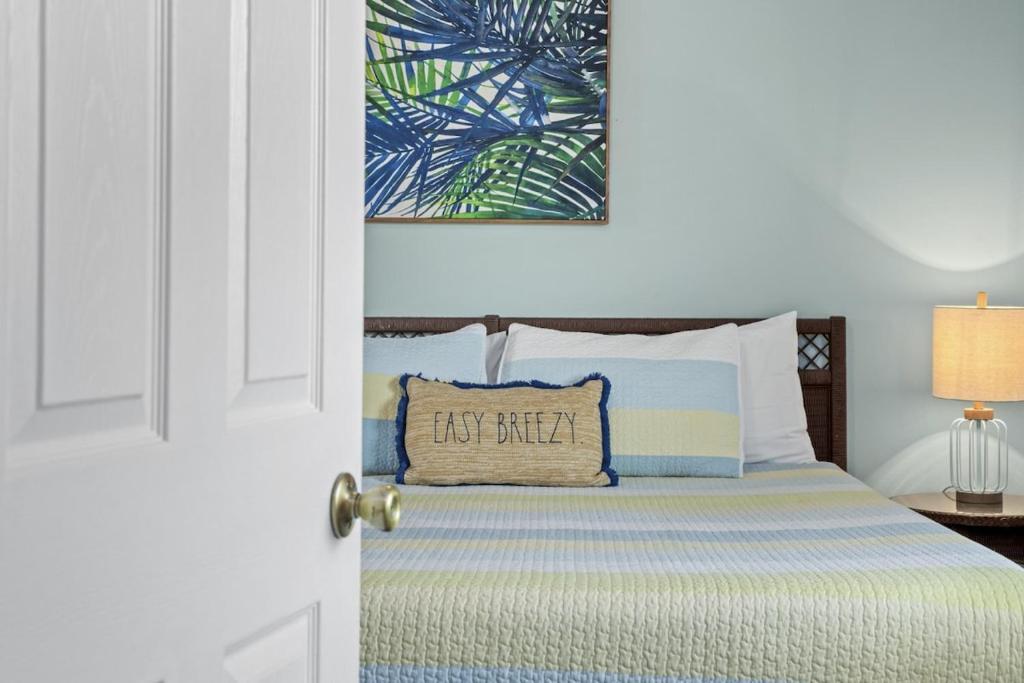 a bedroom with a bed with a pillow on it at SeaCove Steps 2 Priv Beach Backyard Comm Pool in Destin