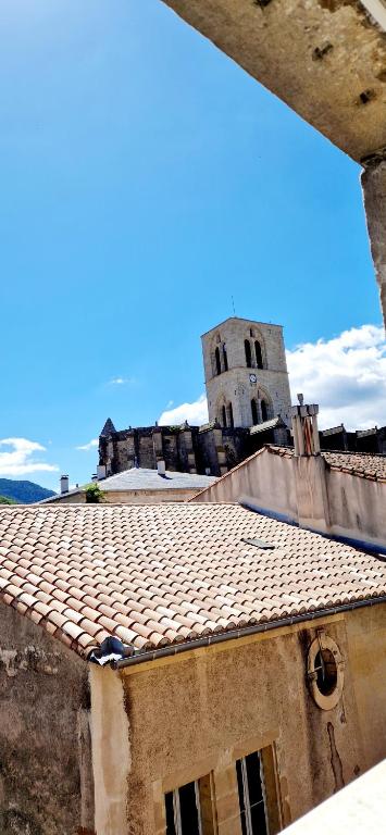 a building with a tower and a tile roof at Appartement plein centre-ville in Lodève