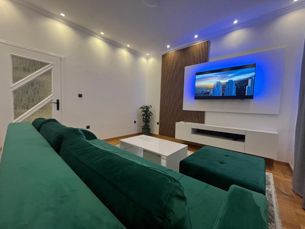 a living room with a green couch and a tv at Sarajevo Luxury Apartment - 50 m from Old Sarajevo Clock Tower in Sarajevo
