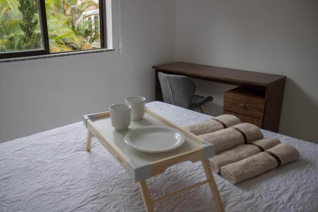 a table with a plate on top of a bed at Ecoapê in Petrópolis
