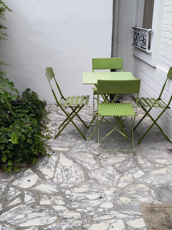 2 chaises, une table, une table et des chaises dans l'établissement Jolie Appartement maison très bien placé, à Épinay-sur-Seine