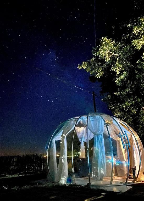 a clear igloo with curtains in it at night at Buby - végtelenbe és tovább in Szigetvár