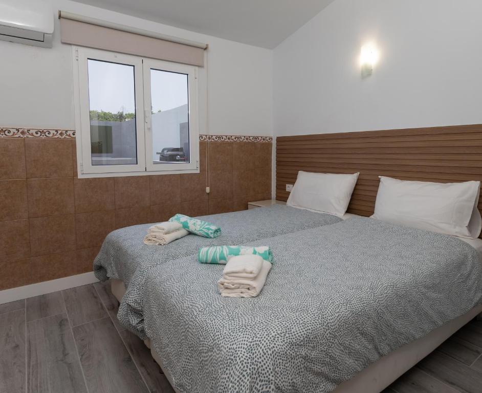 sypialnia z 2 łóżkami i ręcznikami w obiekcie Bungalow Playa del Inglés w mieście San Bartolomé