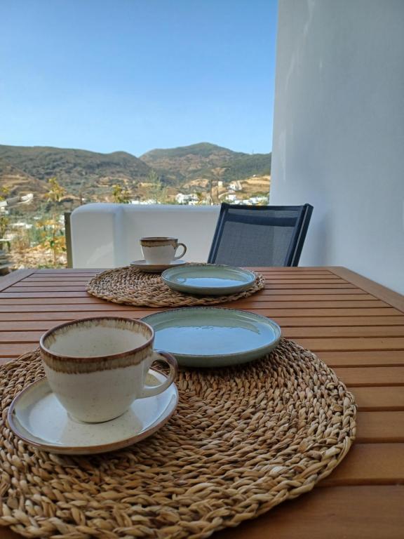a table with two cups and plates on it at aerie home Skyros in Skiros