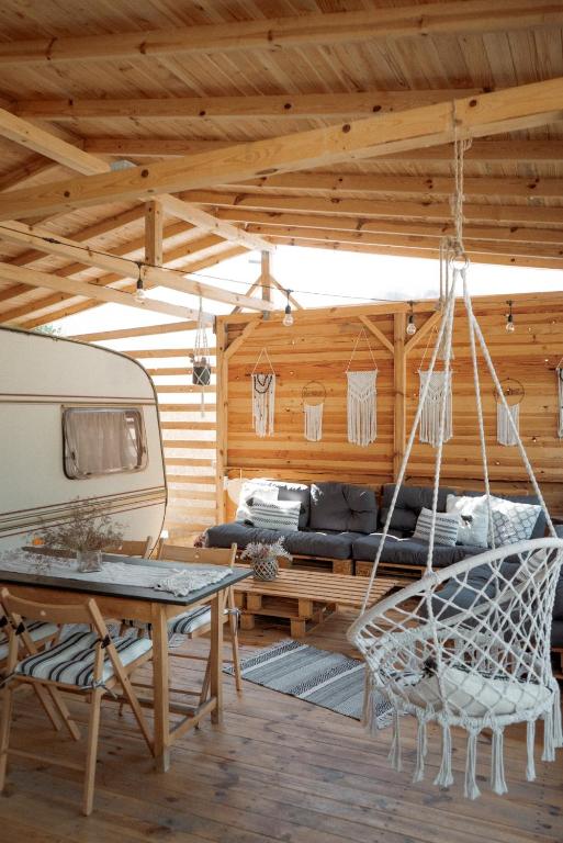 a room with a hammock and a table and a caravan at Каравана Бохемия in Chernomorets