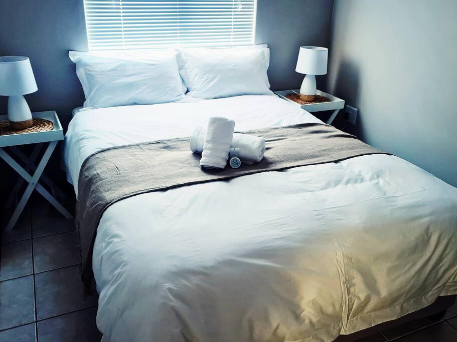 ein Bett mit zwei Kissen darauf mit zwei Lampen in der Unterkunft Cheerful 3-bedroom vacation home in Kathu