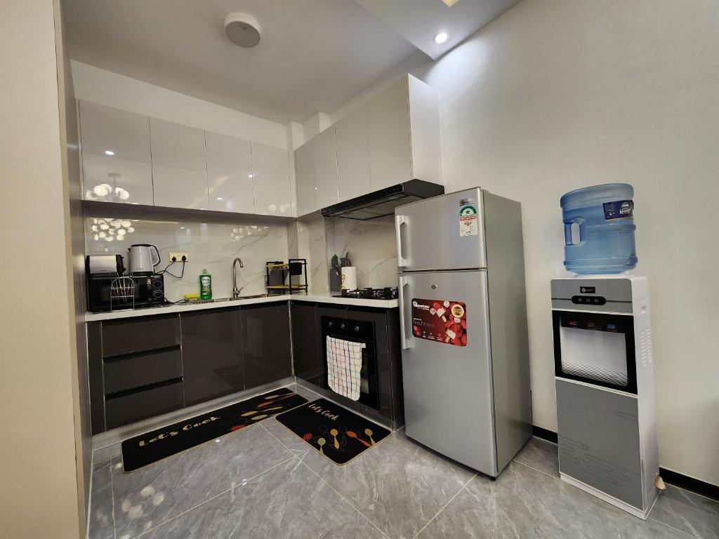 a kitchen with a refrigerator and a stove at Serenity Green Ivy Nandwa Residence in Nairobi