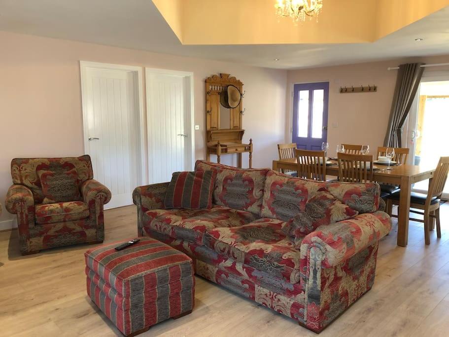 un salon avec un canapé et une table dans l'établissement Barn Owl Lodge with Hot Tub - Adults Only, à Lackford