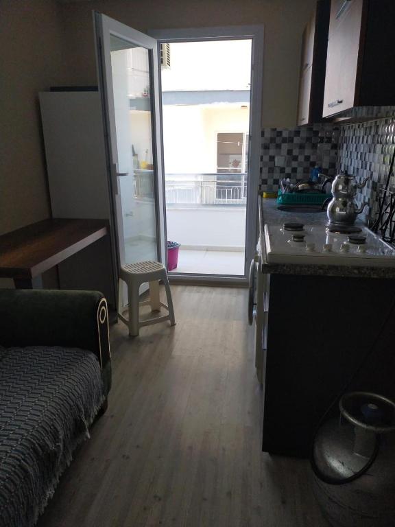 a living room with a kitchen with a counter and a table at Adenaz Apartmanları tatil köyü in Erdemli