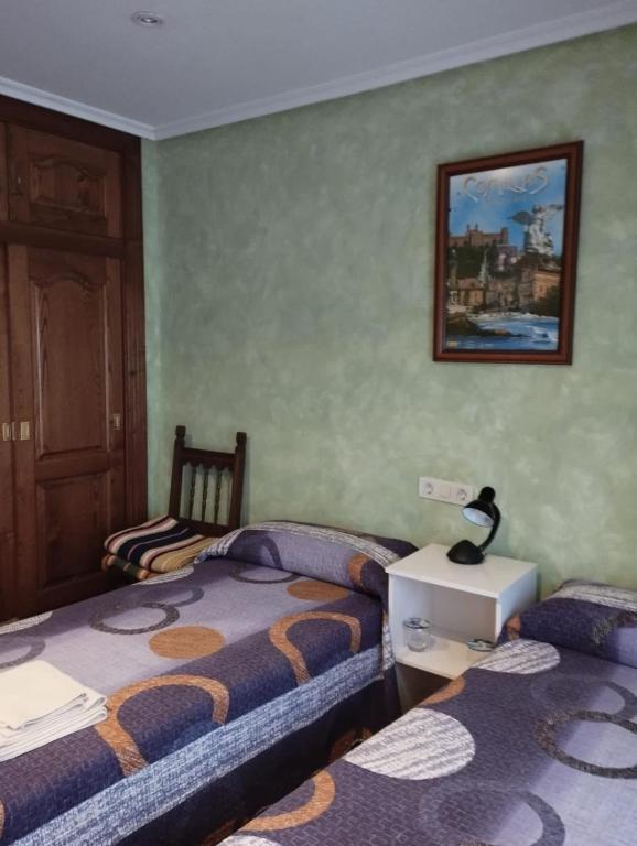 a bedroom with two beds and a picture on the wall at La Casa de Conchi in Comillas