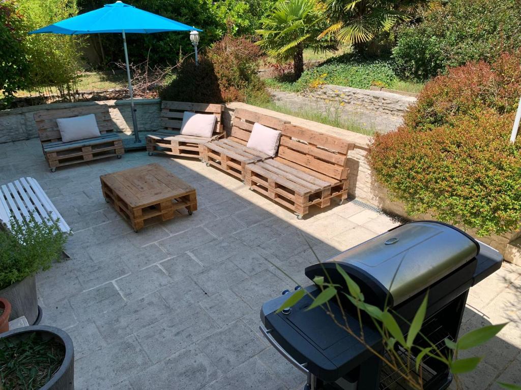 une terrasse avec un banc, des chaises et un parasol dans l'établissement Family House near Paris & Normandy, aux Mureaux