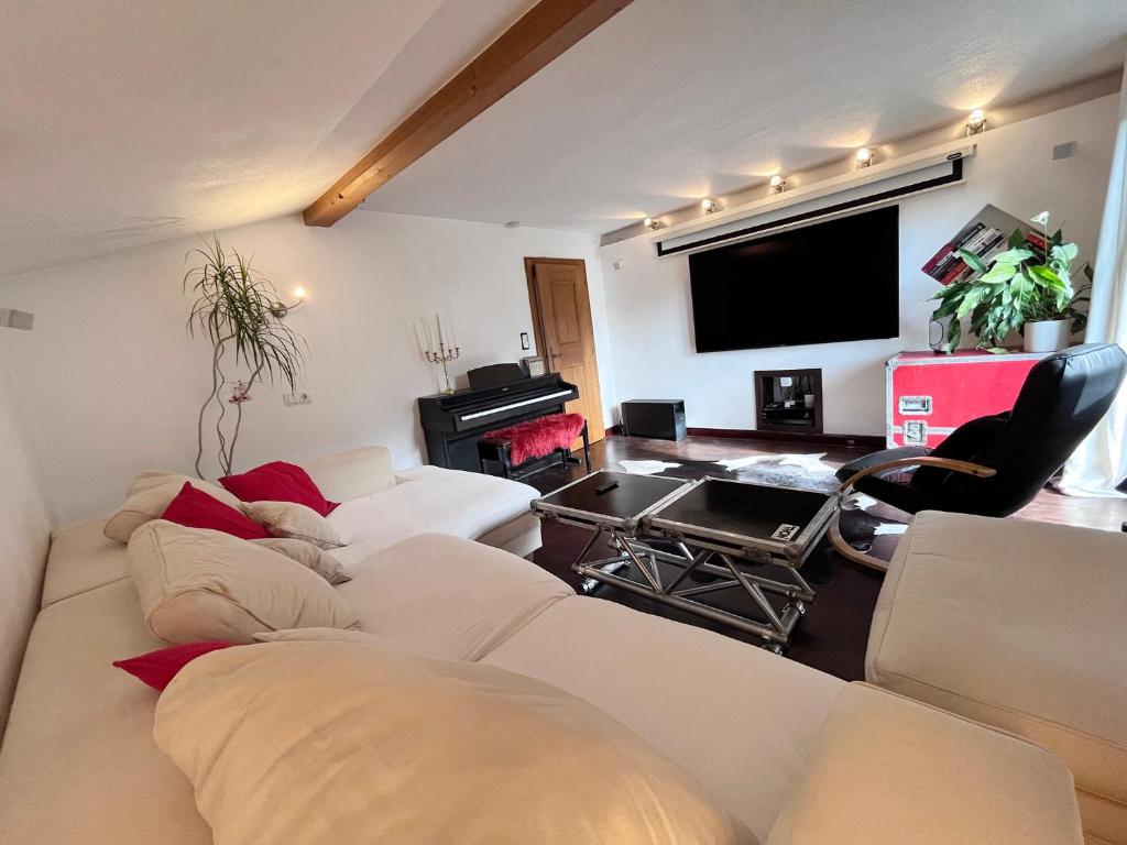 un soggiorno con mobili bianchi e TV a schermo piatto di Lene's Flat a Kitzbühel