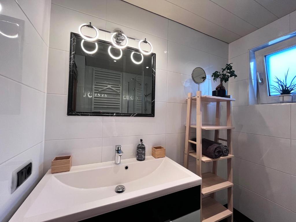 bagno bianco con lavandino e specchio di Lene's Flat a Kitzbühel