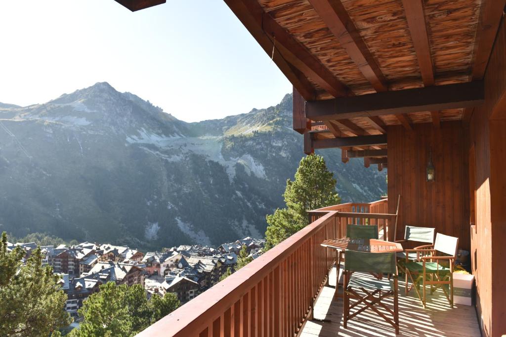 d'un balcon avec une table, des chaises et une montagne. dans l'établissement Chalet le Chamois-Arolles- Arcs 2000-Alpes-France, à Bourg-Saint-Maurice