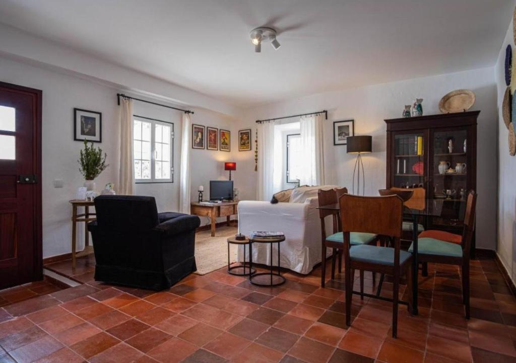 a living room with a couch and a table and chairs at Casa do Largo in Torres Vedras