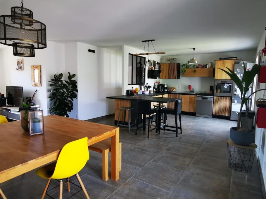a kitchen and dining room with a table and chairs at Agréable Villa proche Pont du Gard in Bezouce