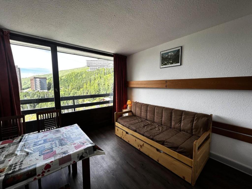 un salon avec un canapé et une table dans l'établissement Résidence Chaviere - Au coeur des Menuires appartement 2 pers MAE-4294, aux Menuires