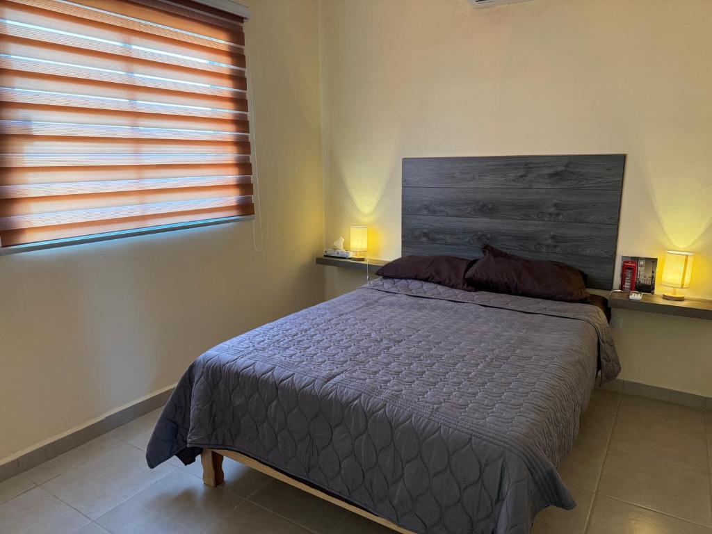 a bedroom with a bed and a window with two lamps at Altamira House in La Paz