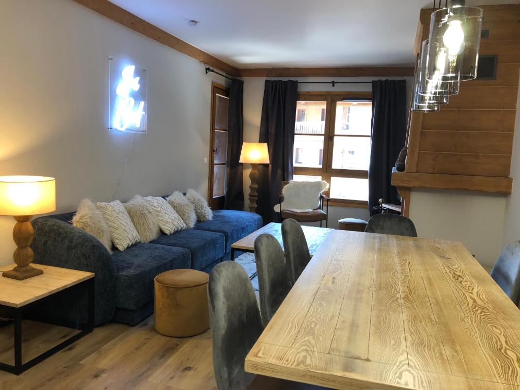 un salon avec un canapé bleu et une table dans l'établissement Chalet Alouette, 3 bed, Arc 1950, à Arc 1950