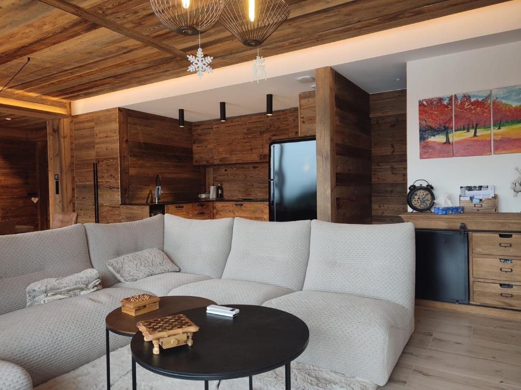 un salon avec un canapé blanc et une table dans l'établissement Rooftop des Glovetes, à Villard-de-Lans