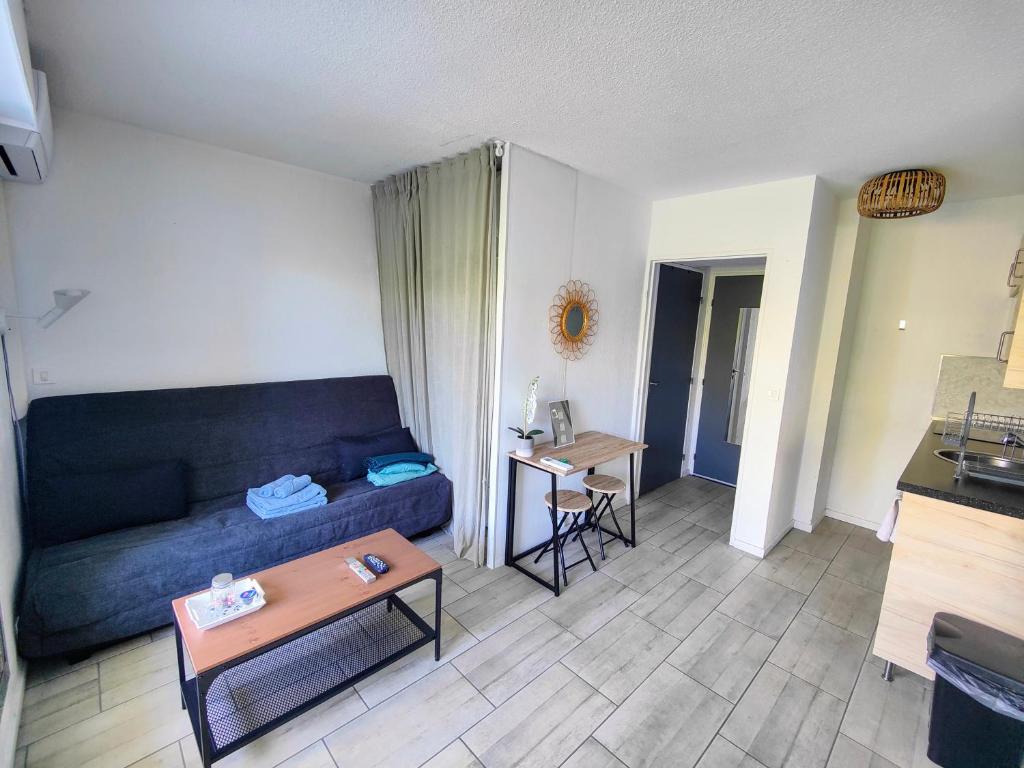 un salon avec un canapé et une table dans l'établissement Joli studio à la Grande Motte, à La Grande Motte