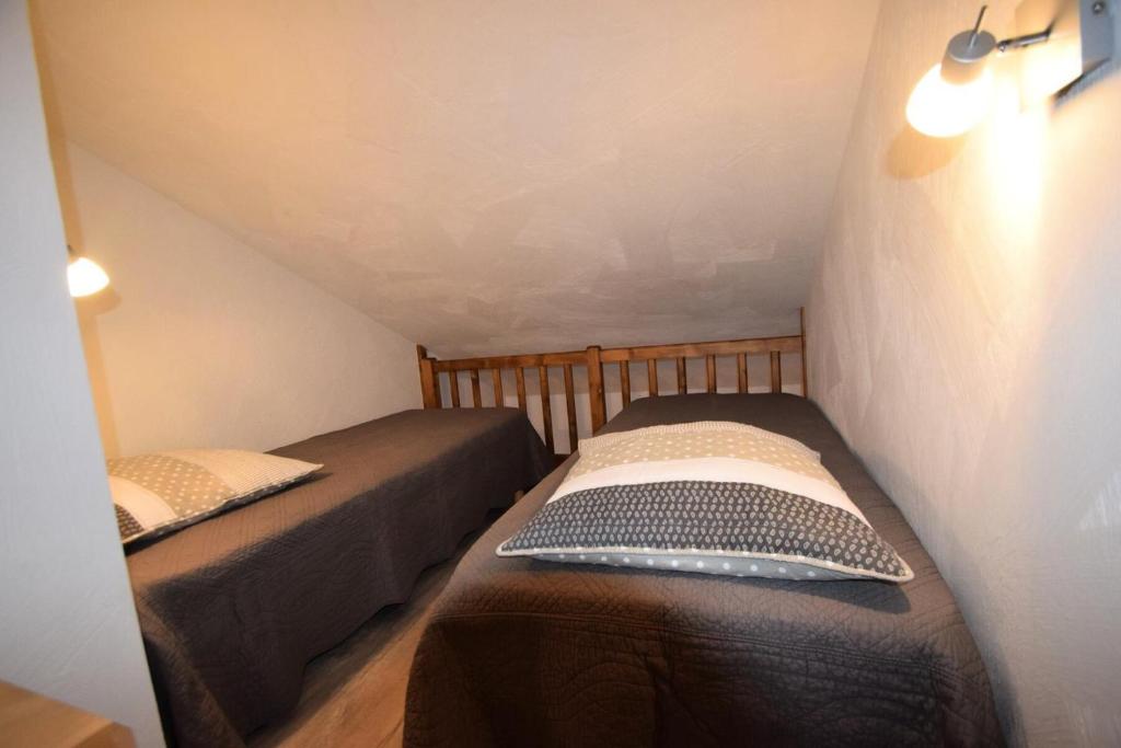 dwa łóżka pojedyncze w małym pokoju z antresolą w obiekcie Résidence Le Cervin - 3 Pièces 6 pers Duplex - WIFI- LE CERVIN - PLAGNE SOLEIL MAE-8924 w Aime La Plagne
