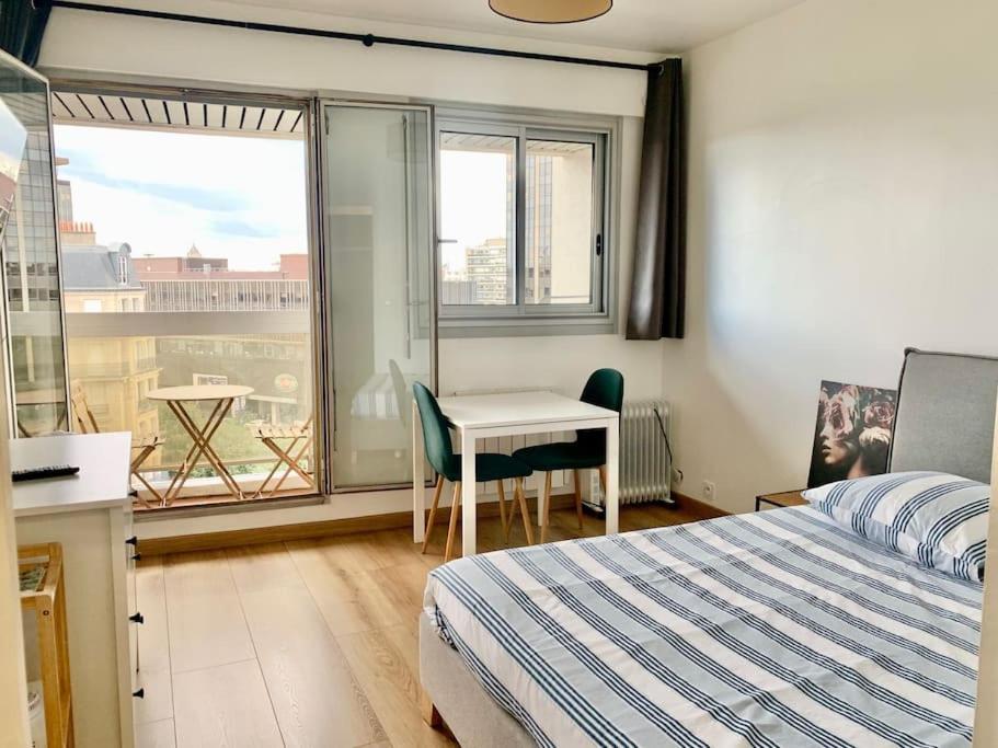 une chambre avec un lit, un bureau et une fenêtre dans l'établissement Cosy studio Balcon Paris Montparnasse, à Paris
