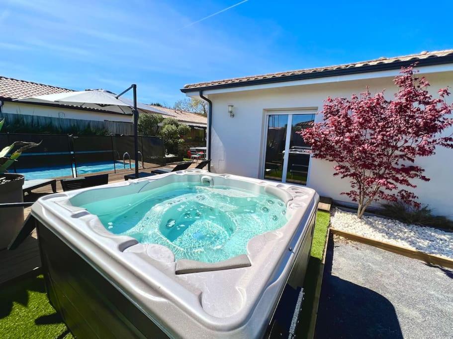 a hot tub in the yard of a house at Spa, Climatisation, Piscine chauffée, Pétanque et Calme au Bassin d'Arcachon in Le Teich
