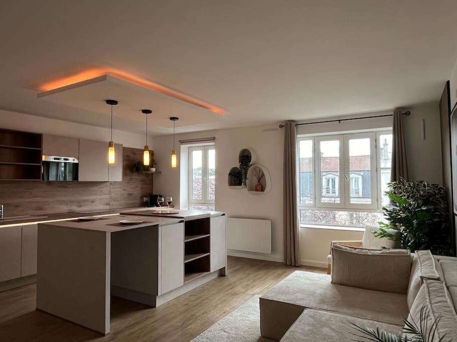 une cuisine et un salon avec un îlot au milieu dans l'établissement Appartement 52m2, neuf, à deux pas de la Gare, à Poissy