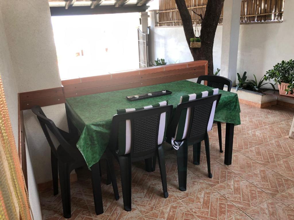 a green table with black chairs and a green table and chairsearcher at Casa Turusele in Santa Maria Navarrese
