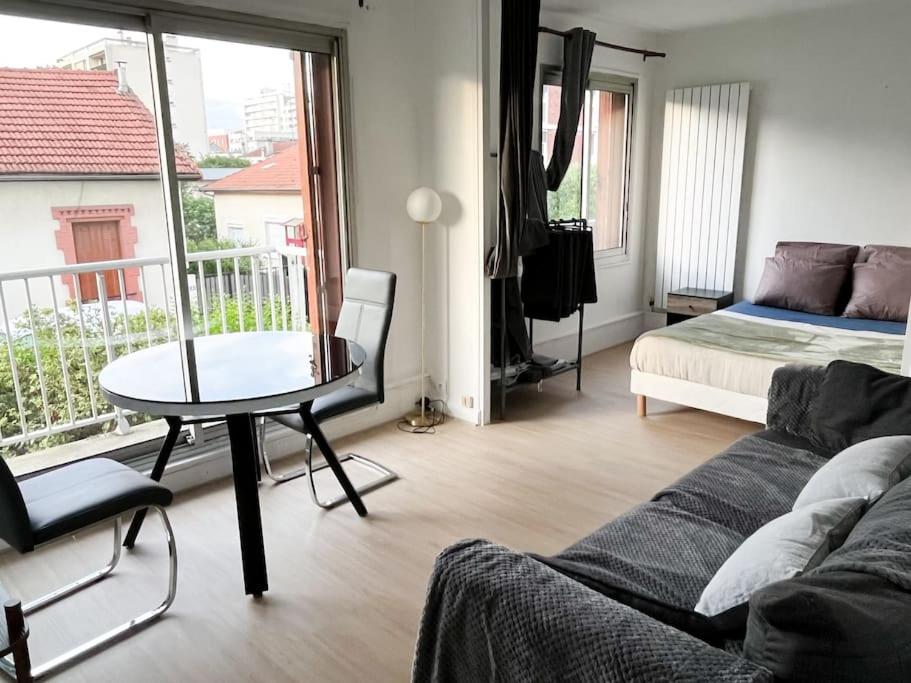 un salon avec un lit, une table et un canapé dans l'établissement Apartment 15 min to Paris 1 min from subway, à Villejuif