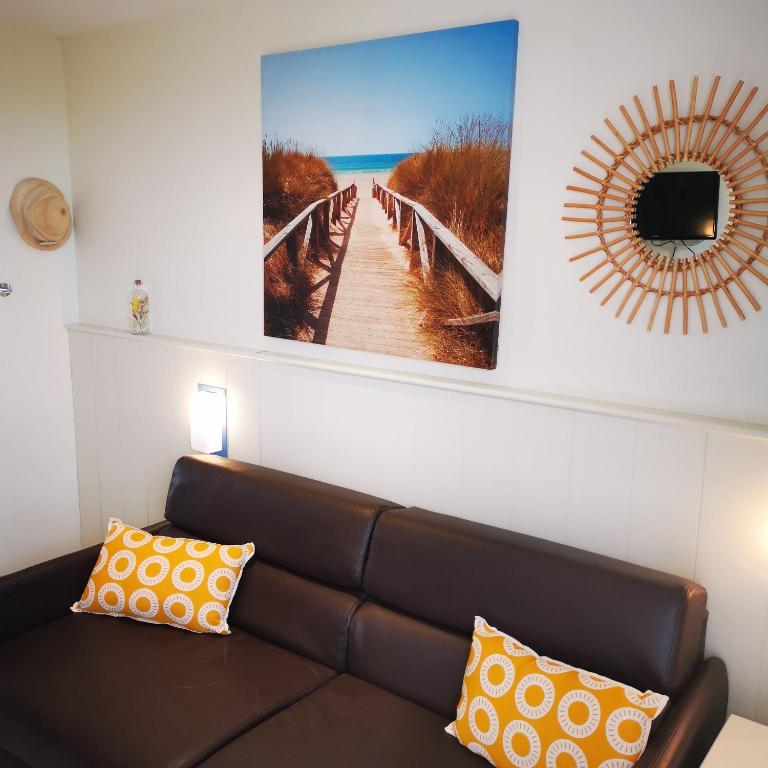 un salon avec un canapé et un tableau au mur dans l'établissement Gîte de l'océan, vue mer avec piscine, à Guidel-Plage