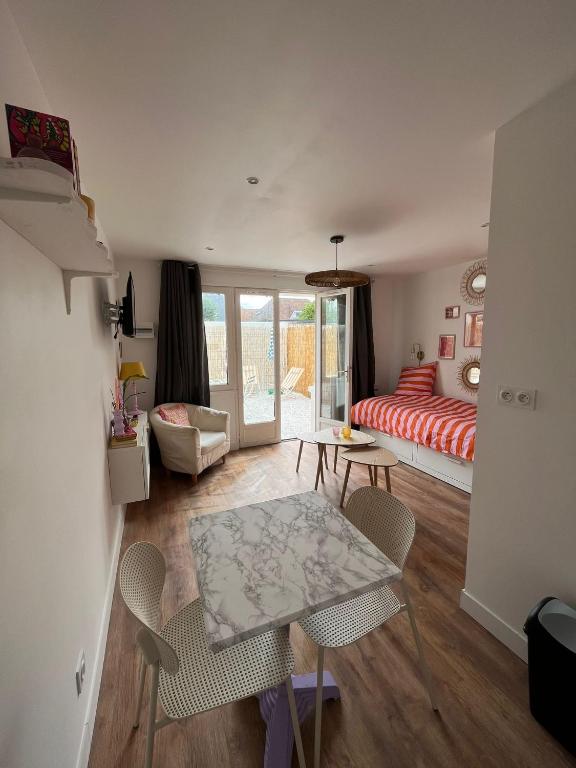 un salon avec un lit, une table et des chaises dans l'établissement Appartements - Riva Bella, à Ouistreham
