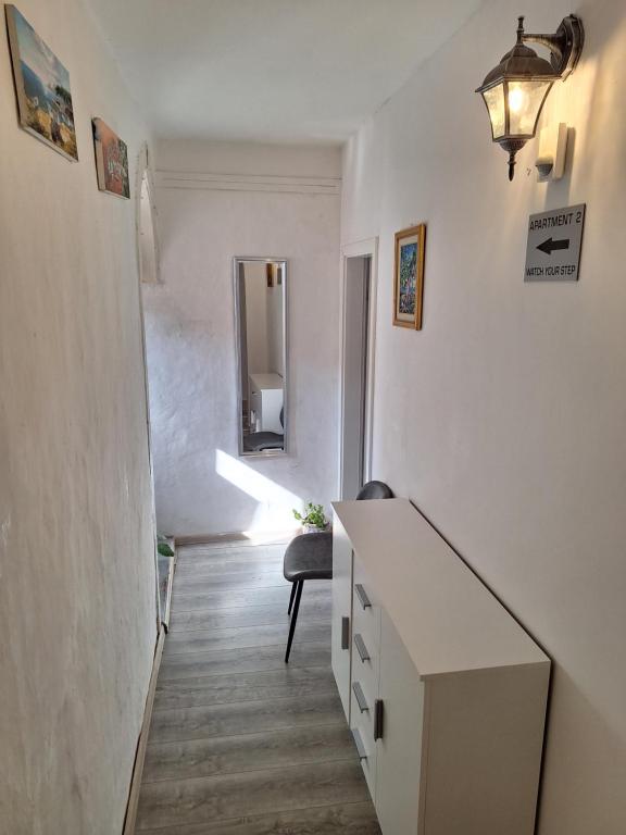 - un couloir blanc avec un bureau et un miroir dans l'établissement Dubrovnik sweet little corner apartment, à Dubrovnik