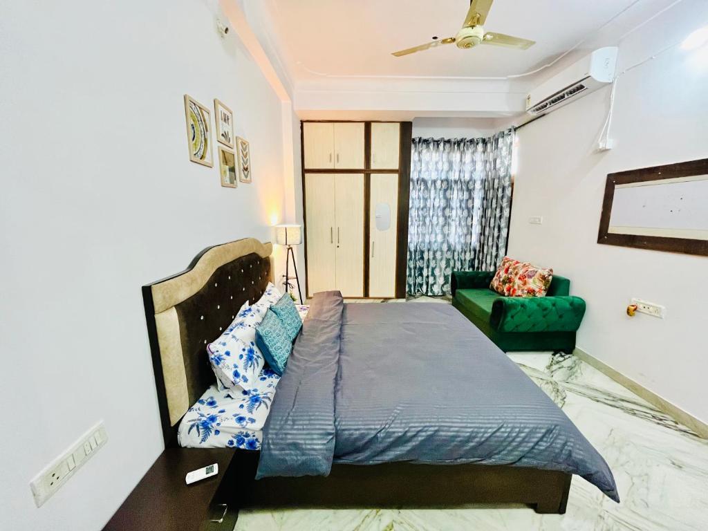 een slaapkamer met een bed en een groene bank bij The Cozy Nook in Udaipur
