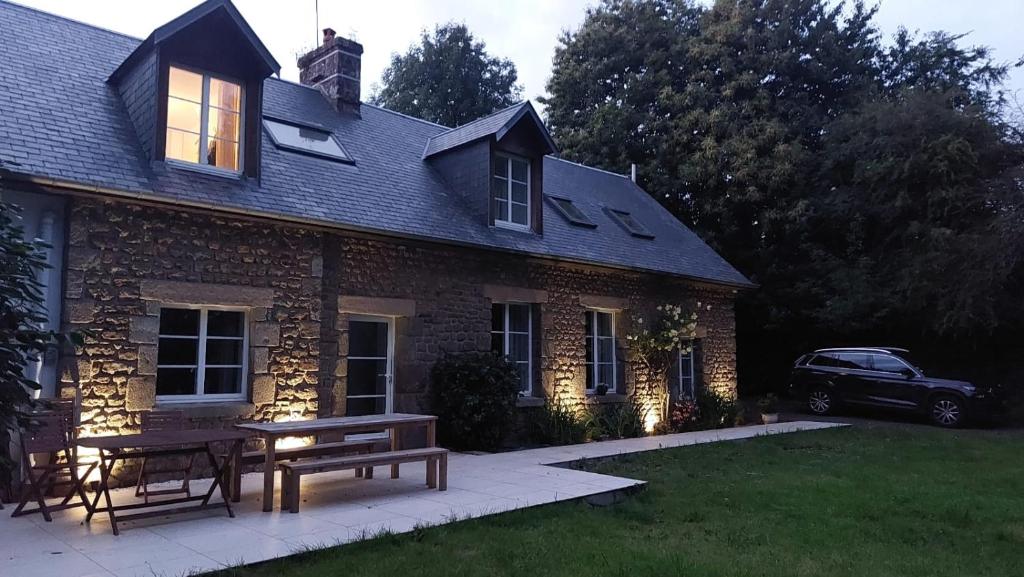 une maison en briques avec une table de pique-nique devant elle dans l'établissement Maison La Rivière, à Reffuveille