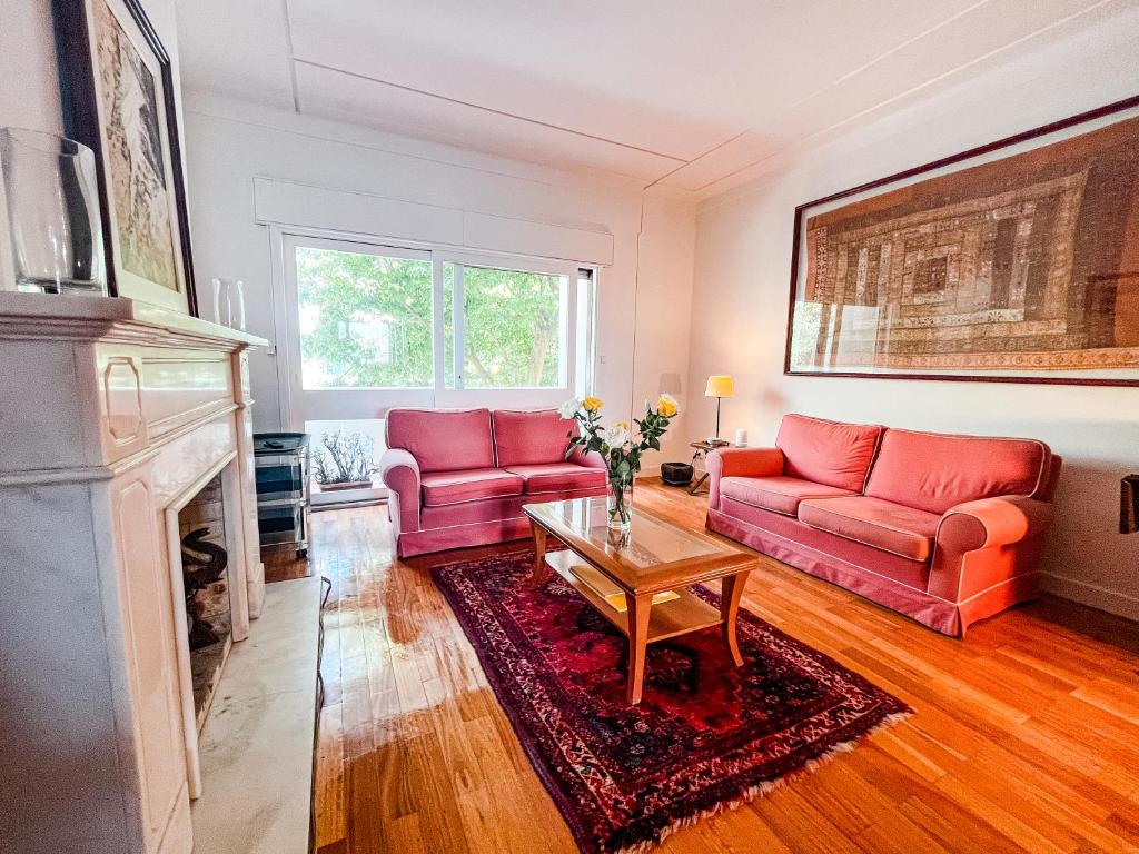 un soggiorno con 2 divani rossi e un camino di Spacious, Luxurious, and Charming Apartment in Premium Porto Location with PARKING a Porto