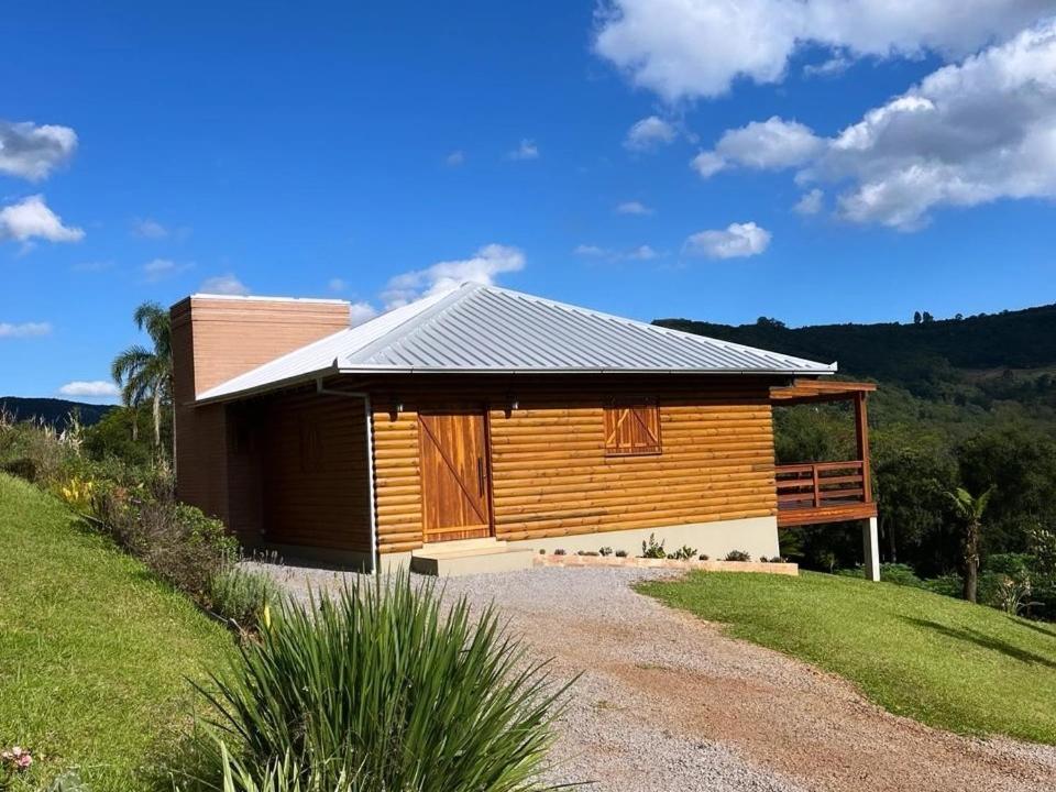 eine kleine Holzhütte mit einem Rasenplatz in der Unterkunft Cabana Bela Vista in Santa Maria do Erval