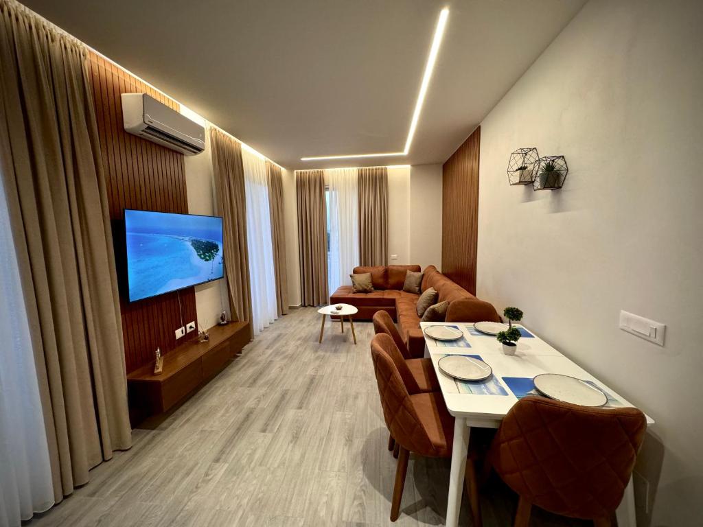 un salon avec un canapé et une table avec des chaises dans l'établissement Roman Apartments, à Vlorë
