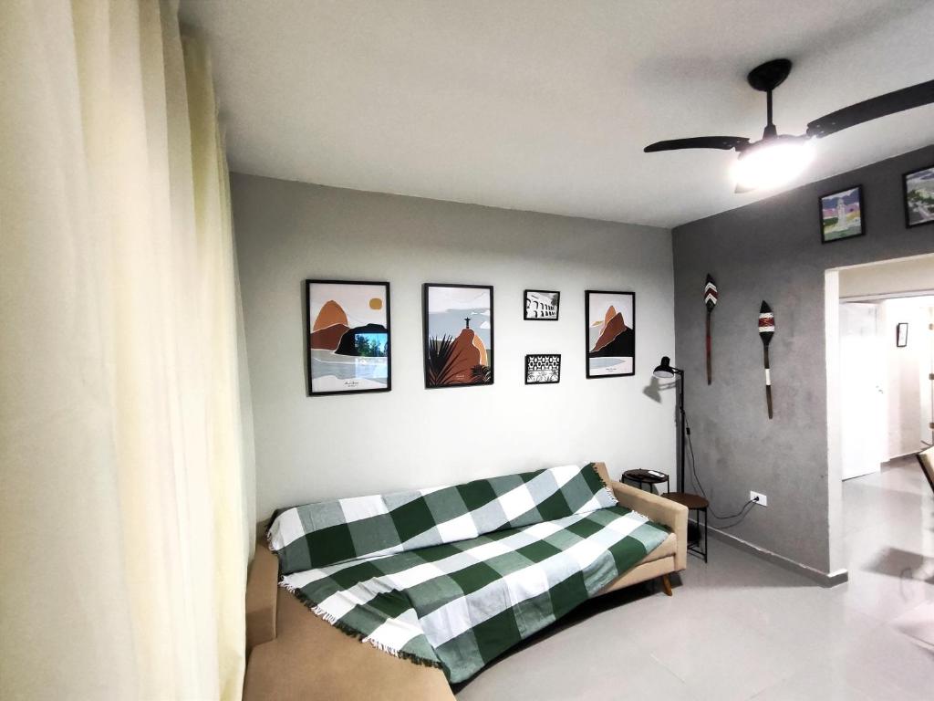 a living room with a couch and pictures on the wall at Casa Ubatubana I, em Praia do Sapê - Ar condicionado, garagem, cozinha completa e Wi-Fi in Ubatuba