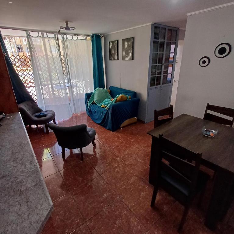 a living room with a blue couch and a table at depa playa in Arica