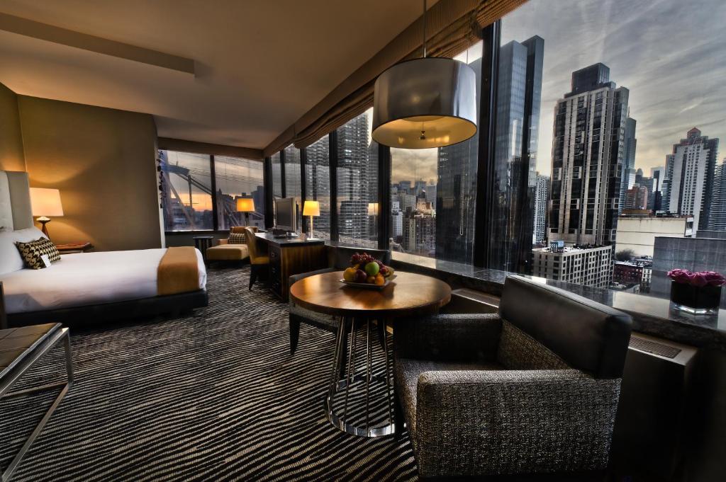 a hotel room with a bed and a large window at Bentley Hotel in New York