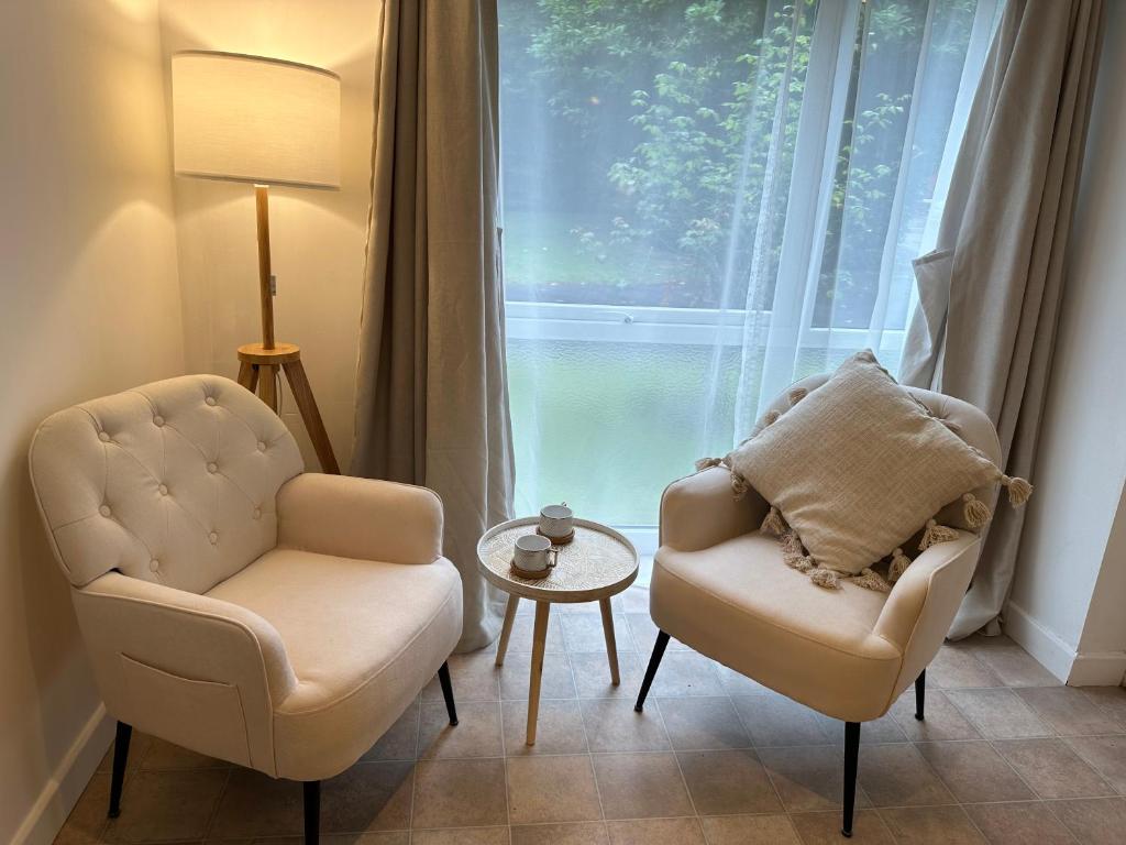 a living room with two chairs and a table and a window at Entire studio flat in Manchester