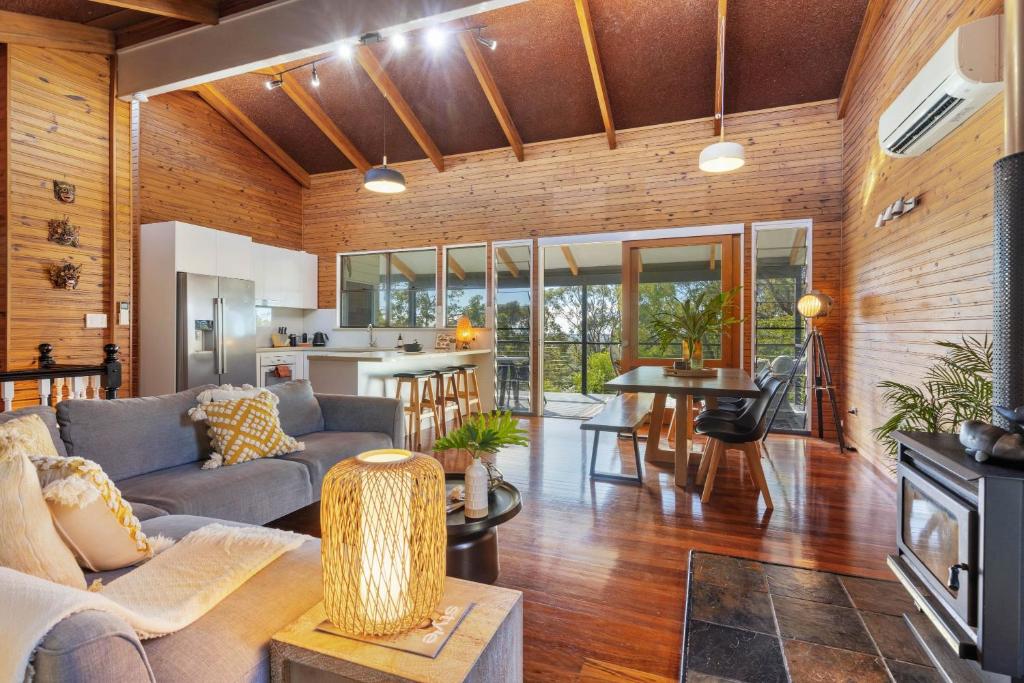 a living room with a couch and a table at Hilltop Hideaway at Coolum Beach in Coolum Beach
