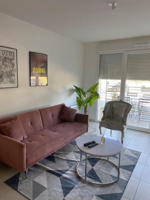 un salon avec un canapé marron et une table dans l'établissement Appartement cosy avec terrasse, à Avignon