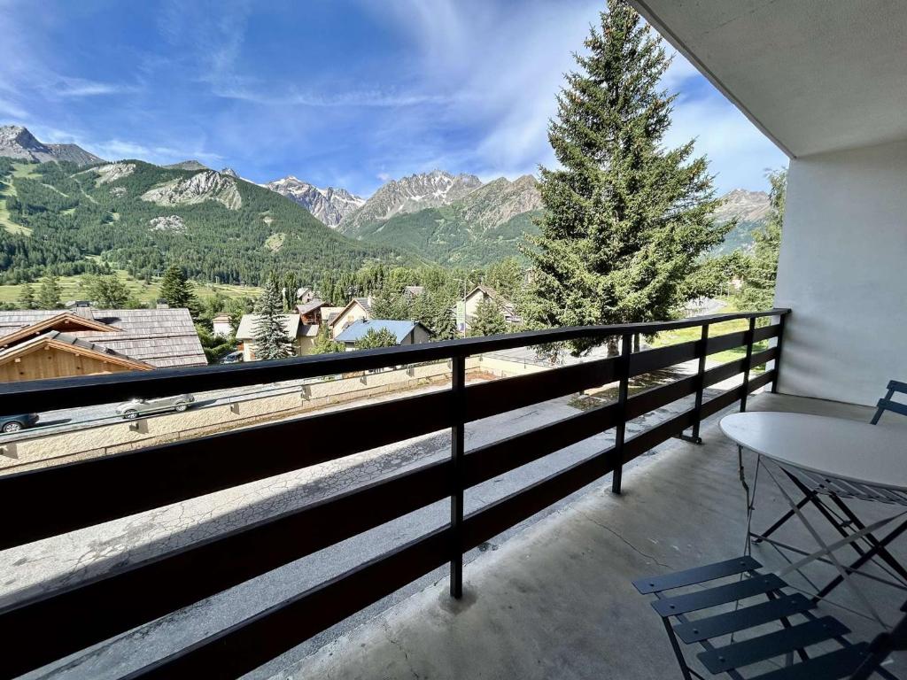 un balcon avec une table et une vue sur les montagnes dans l'établissement Charmant T2 rénové, balcon sud, proche commerces - FR-1-330F-238, au Monêtier-les-Bains