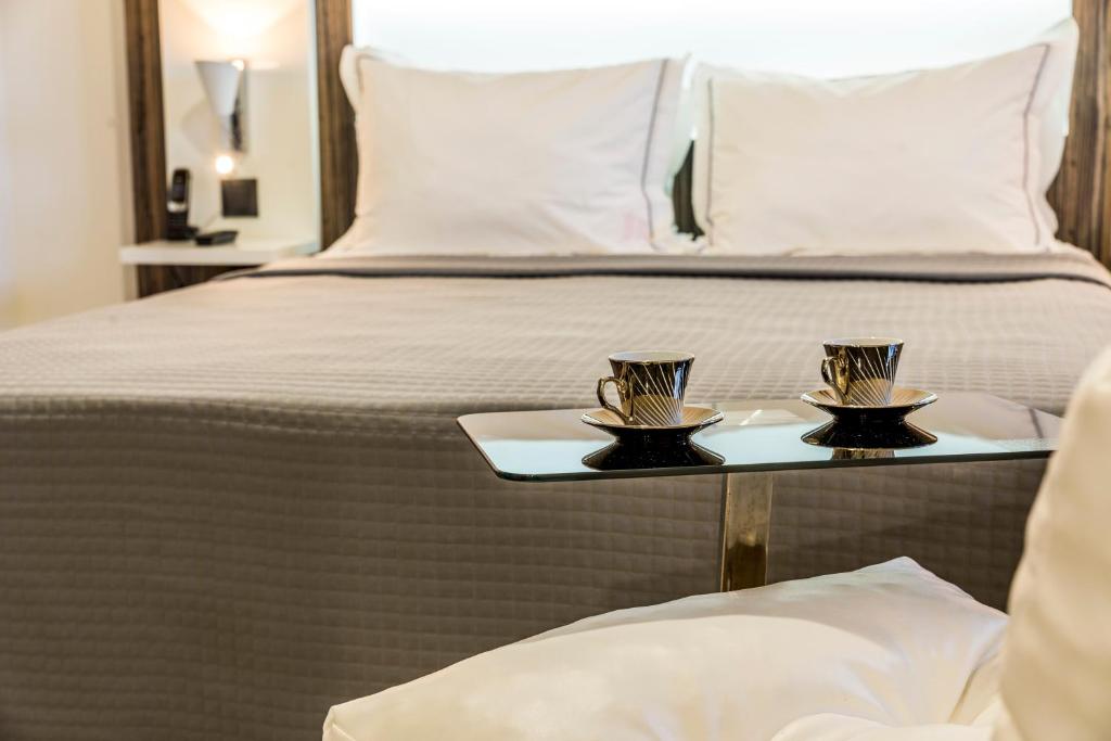 a bed with two trays with cups on it at Residence Fort Savane in Fort-de-France