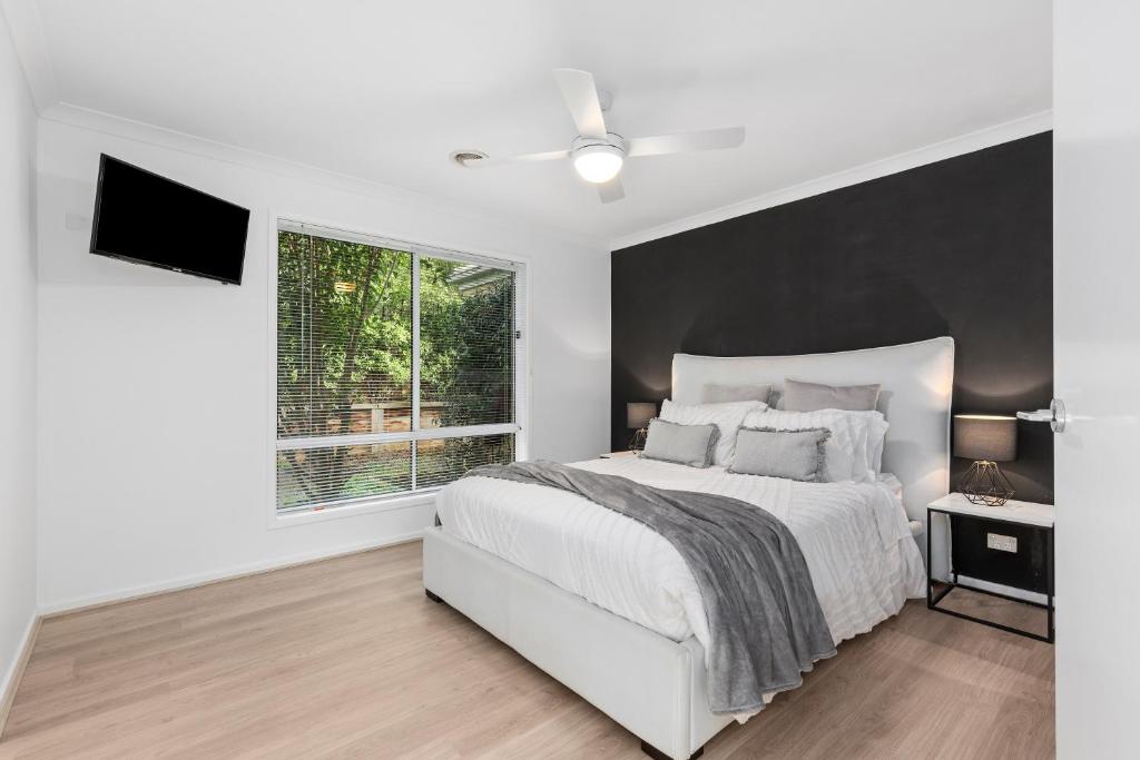 a white bedroom with a large bed and a window at Haven in Grove quiet area, comfort, close to beach and shops in Ocean Grove